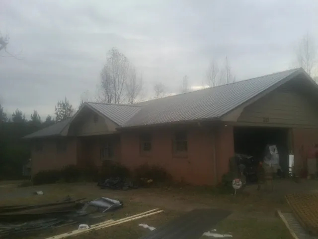Gray metal roof on a stucco house with an attached garage in Loveland